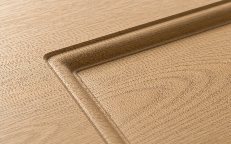Molded door skin surface with embossed pattern detail
